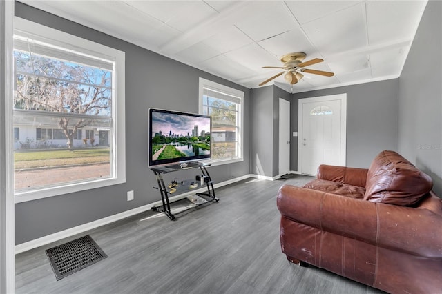 living room with wood-type flooring, ceiling fan, and ornamental molding