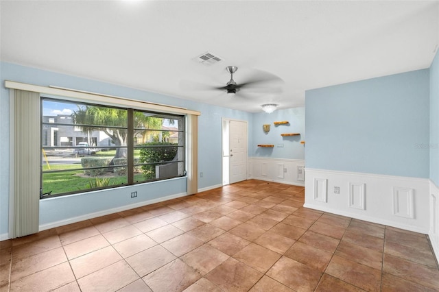 tiled spare room featuring ceiling fan