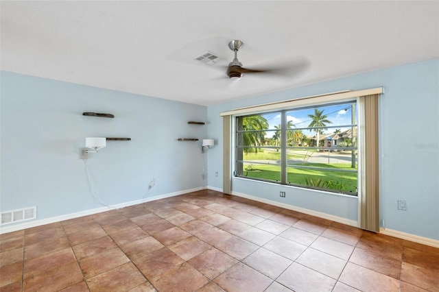 tiled spare room featuring ceiling fan