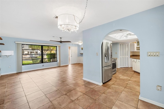 kitchen with white cabinets, ceiling fan with notable chandelier, light tile patterned floors, and appliances with stainless steel finishes