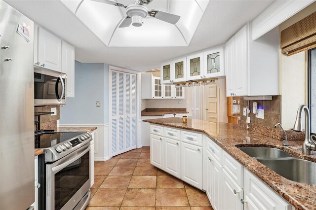 kitchen featuring white cabinets, stone counters, appliances with stainless steel finishes, and sink