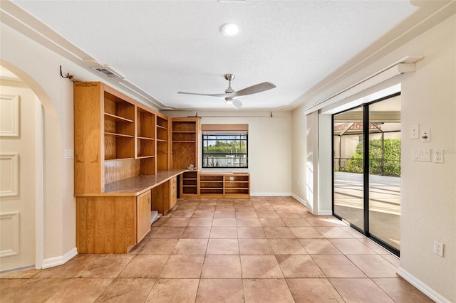 unfurnished office with light tile patterned flooring, a textured ceiling, and ceiling fan