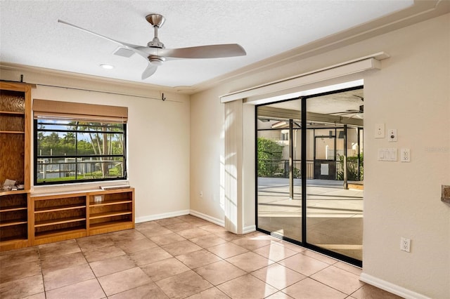 tiled spare room with a textured ceiling and ceiling fan