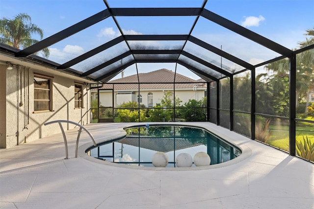 view of pool featuring glass enclosure and a patio