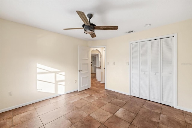 unfurnished bedroom featuring a closet, ceiling fan, and tile patterned floors