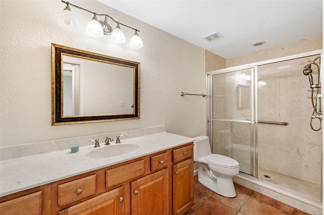 bathroom featuring toilet, a shower with shower door, and vanity