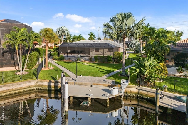 dock area featuring a water view, a lawn, and a lanai