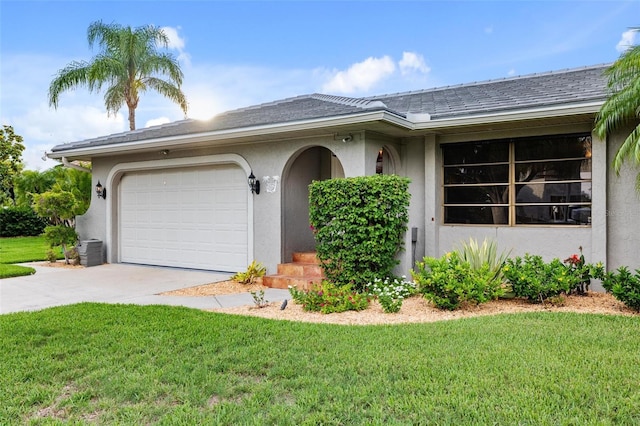 ranch-style home featuring cooling unit, a front yard, and a garage