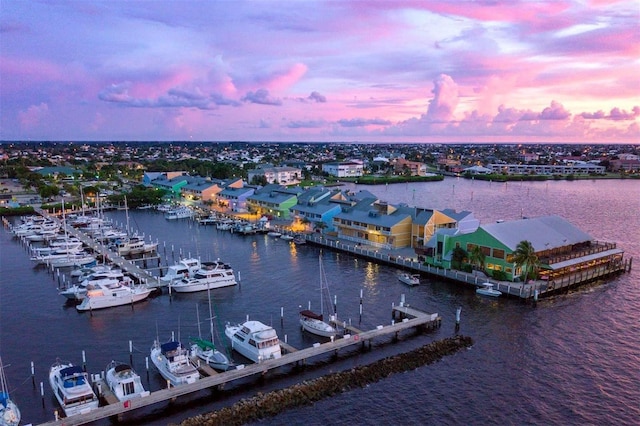 aerial view at dusk featuring a water view