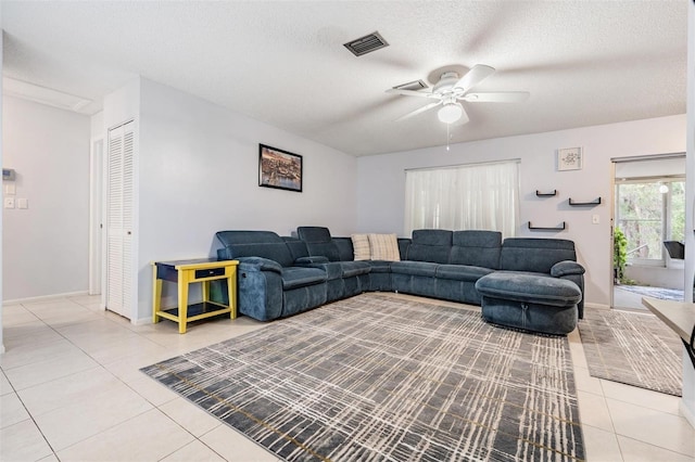 living room featuring ceiling fan, a textured ceiling, and light tile patterned floors