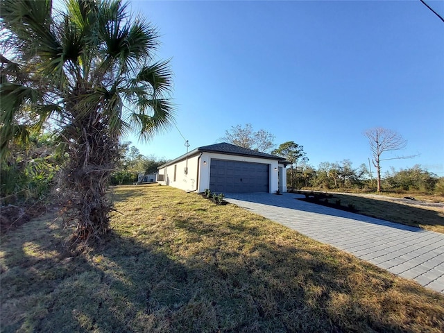 view of side of home featuring a garage and a lawn