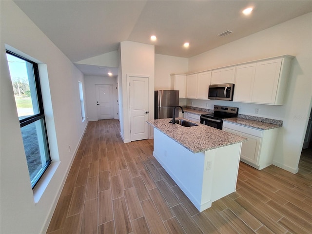 kitchen with white cabinetry, appliances with stainless steel finishes, and an island with sink