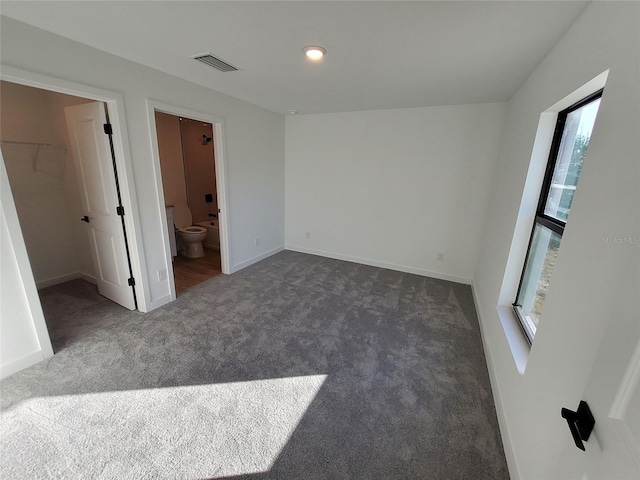 unfurnished room featuring dark colored carpet