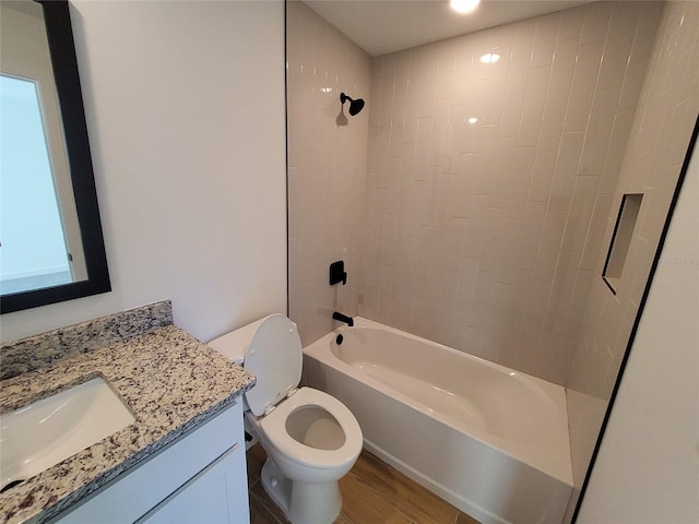 full bathroom with vanity, toilet, tiled shower / bath combo, and hardwood / wood-style floors