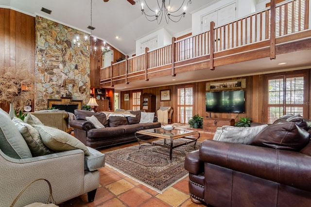 living room with a towering ceiling, an inviting chandelier, and wooden walls