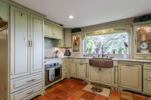 kitchen featuring sink, oven, decorative backsplash, dark tile patterned floors, and black electric stovetop