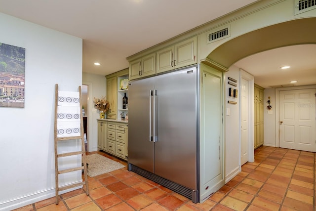 kitchen featuring built in refrigerator and green cabinets