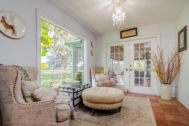 sitting room with a notable chandelier, tile patterned floors, and french doors