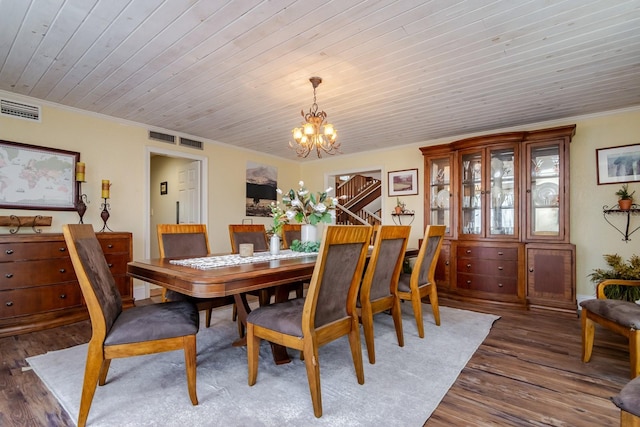 dining area with crown molding, dark wood-type flooring, wooden ceiling, and an inviting chandelier