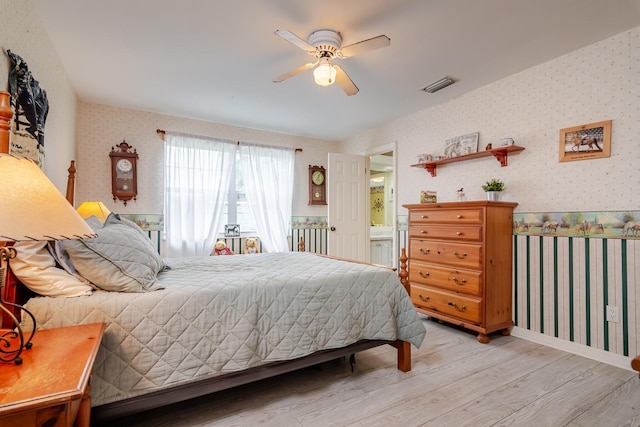 bedroom featuring connected bathroom, ceiling fan, and light hardwood / wood-style floors