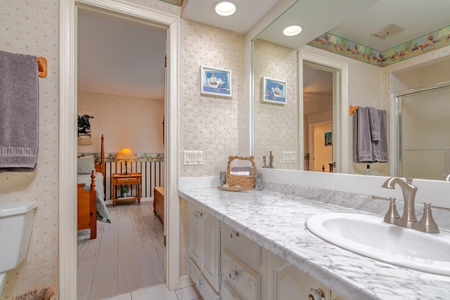 bathroom with vanity, an enclosed shower, and toilet