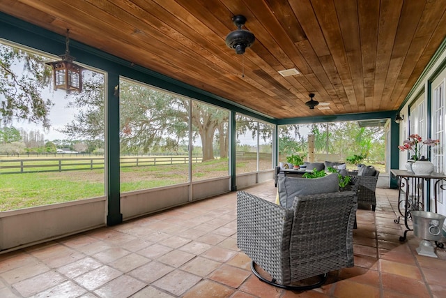 sunroom featuring a rural view, wood ceiling, and a wealth of natural light