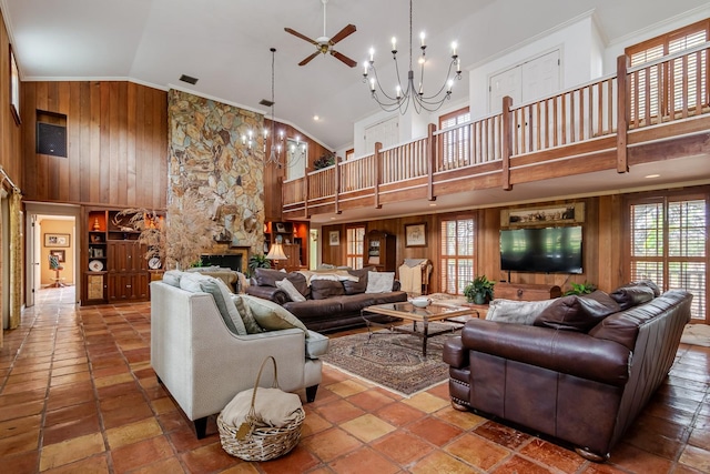 living room featuring crown molding, wooden walls, high vaulted ceiling, and ceiling fan with notable chandelier