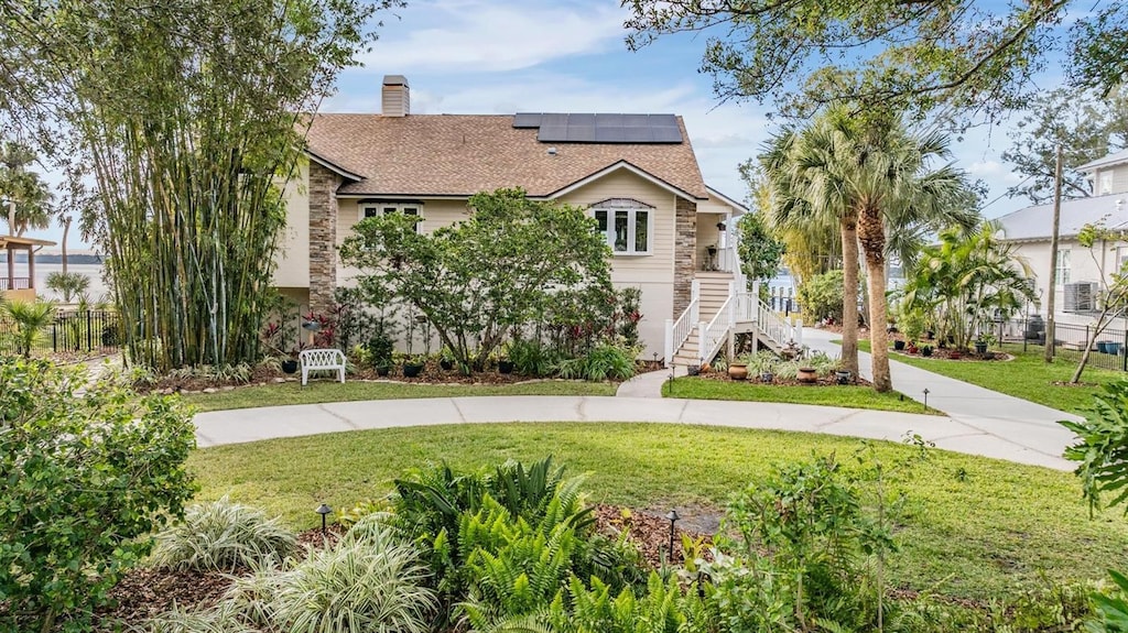 view of front of home featuring a front lawn and solar panels