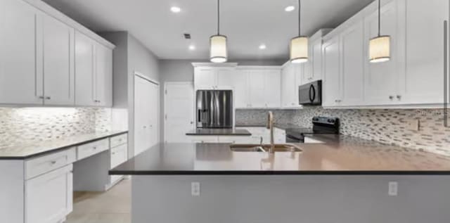 kitchen with white cabinetry, hanging light fixtures, range with electric stovetop, and sink