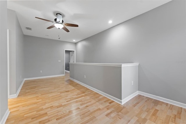 unfurnished room featuring wood finished floors, visible vents, and baseboards