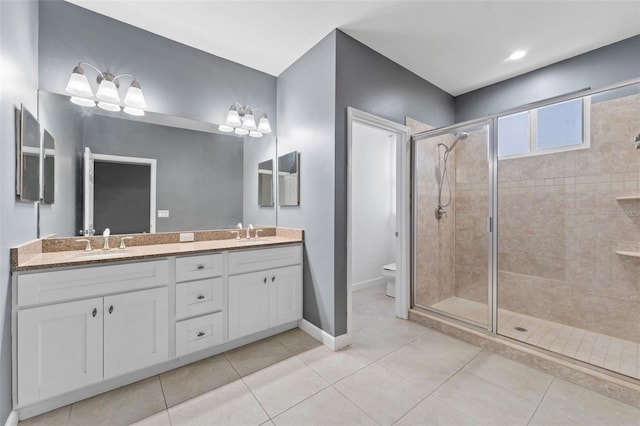 full bath with a sink, a shower stall, toilet, and tile patterned floors