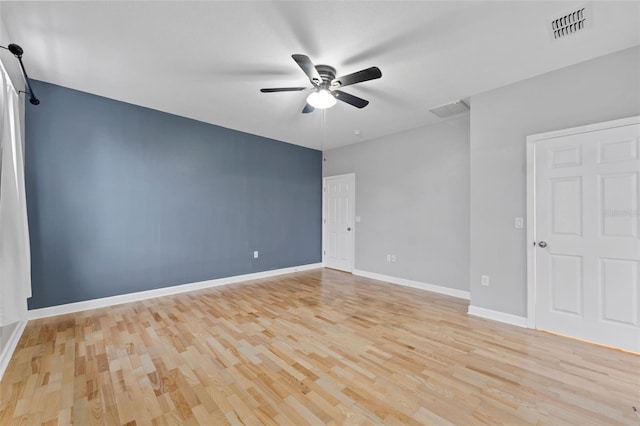 spare room featuring a ceiling fan, baseboards, visible vents, and light wood finished floors