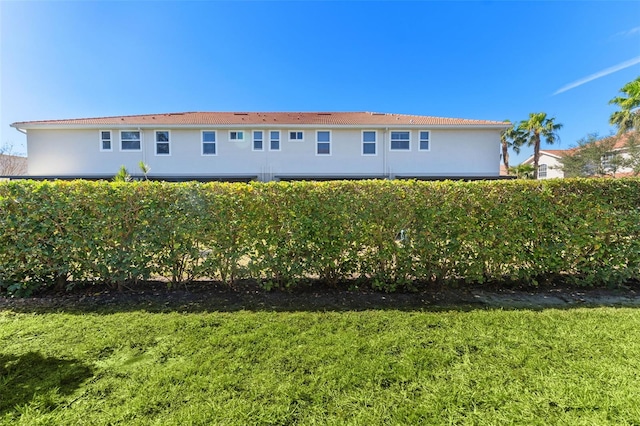 exterior space with stucco siding and a front yard