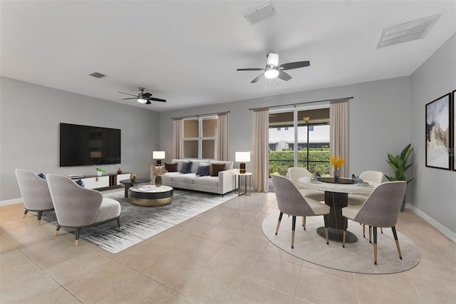 living room with light tile patterned flooring, visible vents, and baseboards