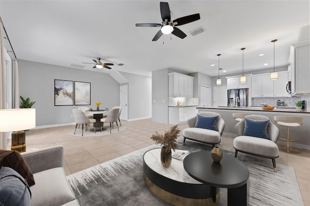 living room with baseboards, light tile patterned flooring, visible vents, and a ceiling fan