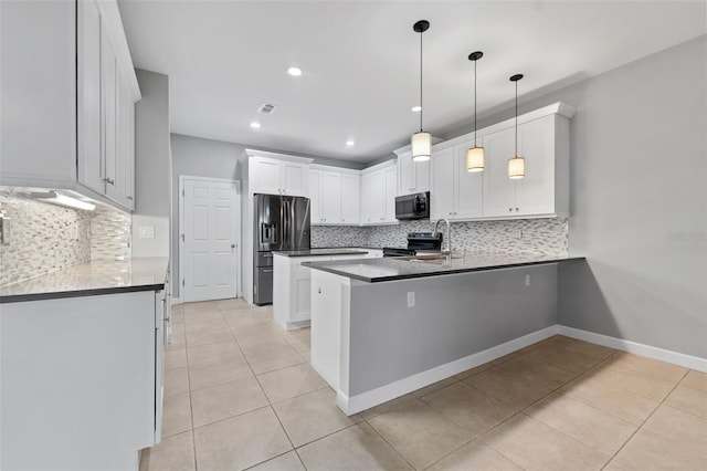 kitchen featuring light tile patterned floors, a peninsula, a sink, white cabinetry, and appliances with stainless steel finishes