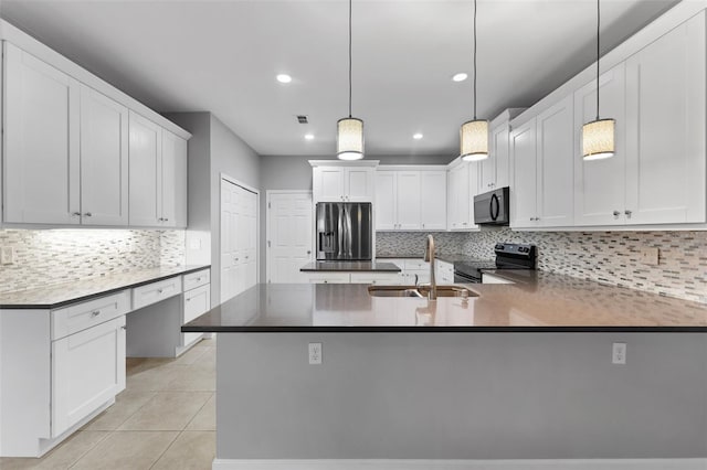 kitchen featuring appliances with stainless steel finishes, tasteful backsplash, a sink, and light tile patterned floors