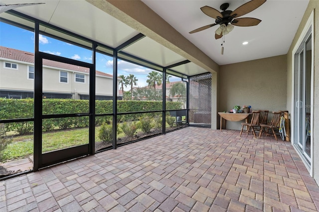 unfurnished sunroom featuring ceiling fan