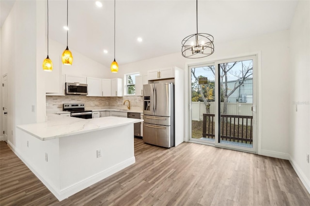 kitchen with white cabinetry, pendant lighting, stainless steel appliances, and kitchen peninsula