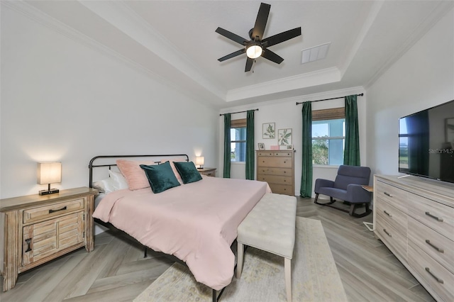 bedroom with a raised ceiling, crown molding, and ceiling fan