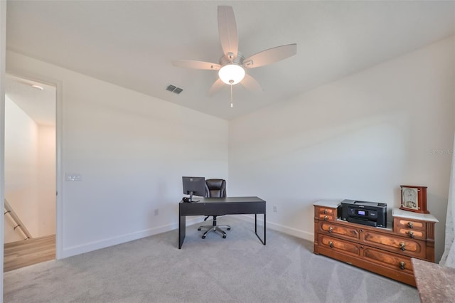 carpeted office space with ceiling fan