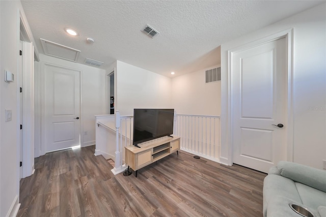 living room with dark hardwood / wood-style floors and a textured ceiling
