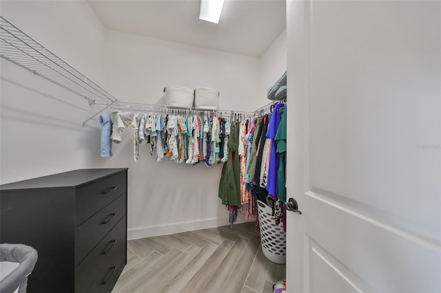 walk in closet with light parquet floors