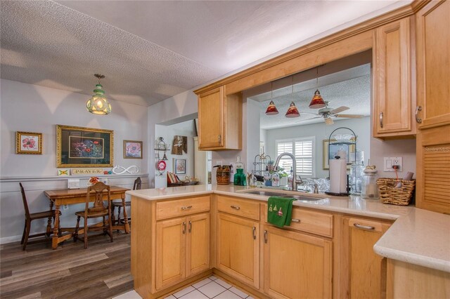 kitchen featuring sink, a textured ceiling, light wood-type flooring, kitchen peninsula, and ceiling fan