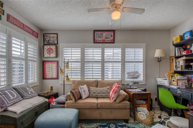 living room featuring ceiling fan, a healthy amount of sunlight, and a textured ceiling