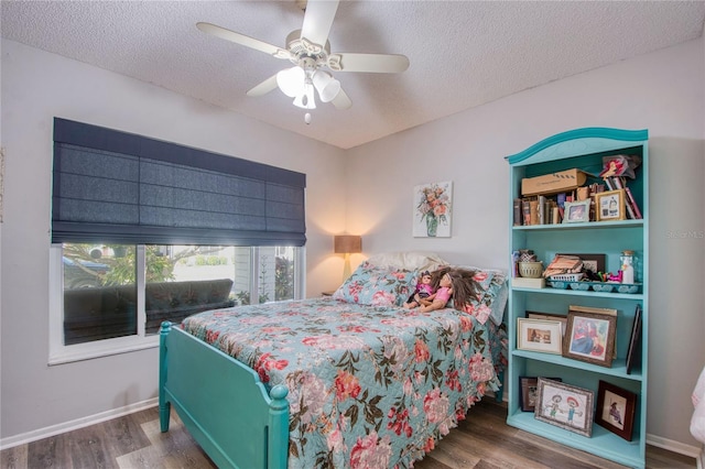 bedroom with ceiling fan, wood-type flooring, and a textured ceiling