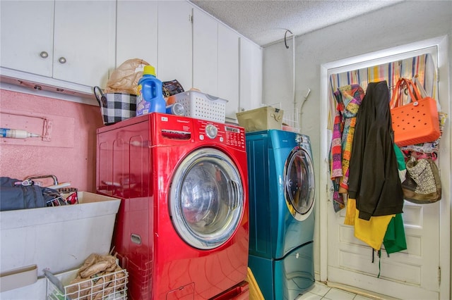 clothes washing area featuring cabinets, sink, washing machine and dryer, and a textured ceiling