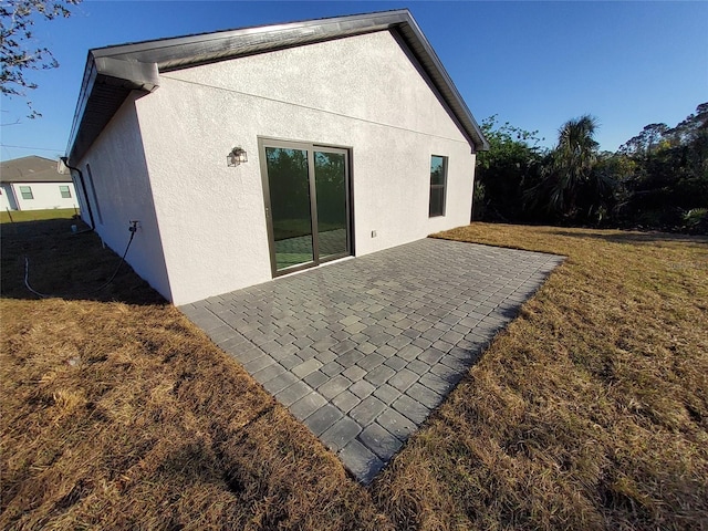 back of house with a patio and a lawn