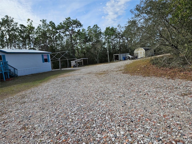 view of yard with a carport and a shed