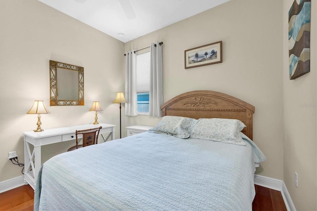 bedroom with dark hardwood / wood-style flooring and ceiling fan